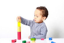 Little Boy Testing His Creativity By Building Towers With Toy Building Blocks
