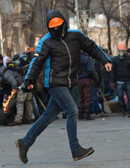 Wall Mural - Street protester with a burning Molotov cocktail against a fire