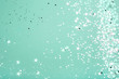 Silver and pink star glitter on teal pastel background. Festive concept. Place for design.