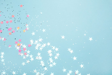 Wall Mural - Silver and pink star glitter on blue pastel background. Festive concept. Place for design.