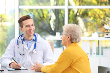 Doctor working with elderly patient in hospital