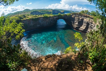 Wall Mural - Rock coastline. Stone arch over the sea. Broken beach, Nusa Penida ,Indonesia.