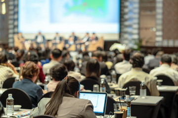 Rear view of Audience listening Speakers on the stage in the conference hall or seminar meeting, business and education about investment concept