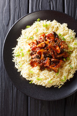 Wall Mural - Delicious fried shiitake mushrooms with garlic and sesame seeds served with rice closeup on a plate. Vertical top view