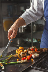 Wall Mural - Chef cooking juicy beef steak at restaurant kitchen