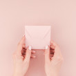 Woman hand holding small pink love letter