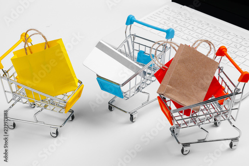 Fotografía Online shopping concept. Shopping cart, laptop on the desk