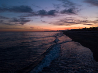 Bellissimo cielo al tramonto infuocato con nuvole arancione e rosso in riva all'oceano calmo. Vista aerea