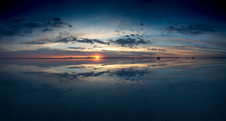 Panoramic sunrise over Salar de Uyuni, Bolivia, with water reflection