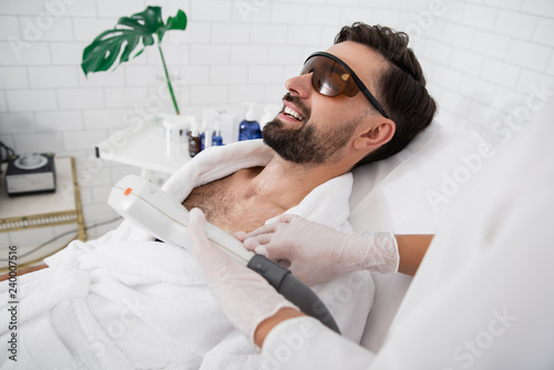 Fotografía Happy man wearing laser safety goggles during hair removal procedure