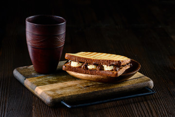 Sticker - Delicious natural and diet sandwich banana with chocolate on a rustic background