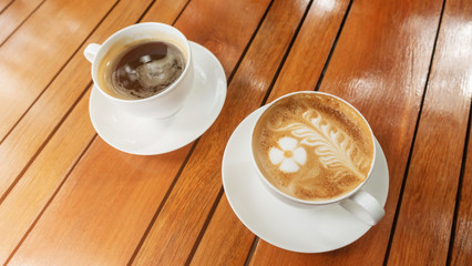 Hot latte coffee and hot americano coffee on a wooden table.