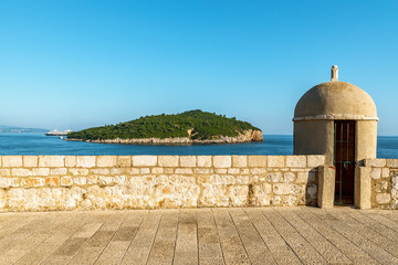 Wall Mural - A Gun turret on old city walls of Dubrovnik with Lokrum in background