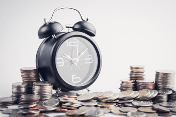 clock and rows of coins for time of finance and business concept