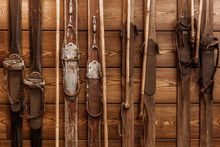 Collection Of Vintage Wooden Weathered Skis. Winter Sport Vintage Equipment On Wooden Wall. Conceptual Background For Design