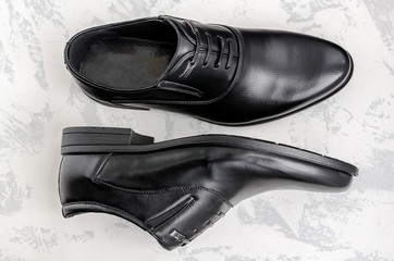 Men's shoes made of black leather on a light background.