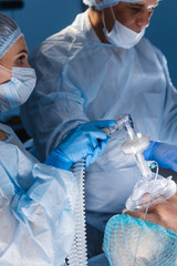 Wall Mural - Assistant Hands hold mask and induction for general anesthesia, Instruments to Surgeons During Operation, close up