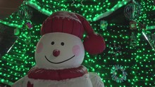 Funny Snowman On The Background Of Christmas Tree, Night Time, Closeup.