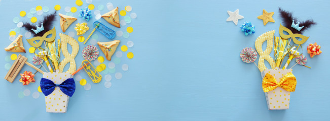 Purim celebration concept (jewish carnival holiday) over blue wooden background. Top view.