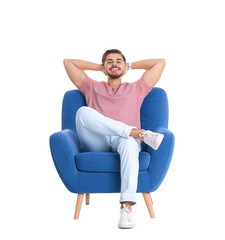 handsome young man sitting in armchair on white background