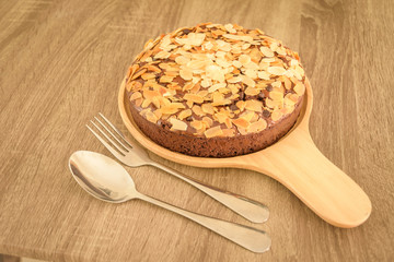 Brownie with almond on wood plate.