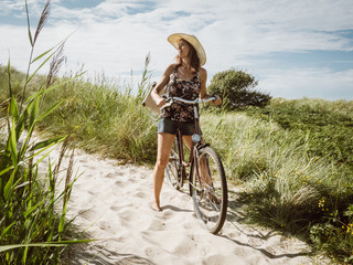 Vintage woman on a bike with a retro suitcase