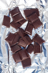 Wall Mural - Several pieces of chocolate of the variety bittersweet lie on a silver paper