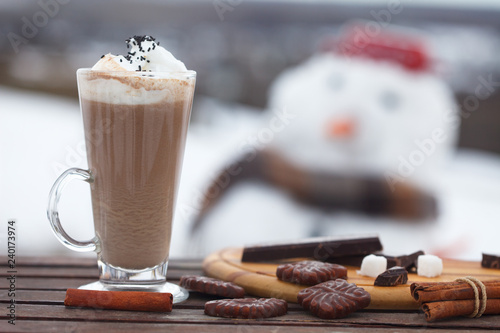 Fotografie, Obraz Glass of hot chocolate or cappuccino with cream and chunks of dark chocolate on wooden table