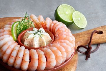 Close-up on shrimp ring with fresh cheese and lime on wooden board