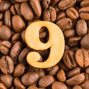 9, Number on wood- background of coffee beans.