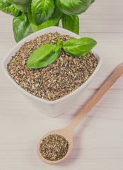 Fresh and dried basil on a wooden background.