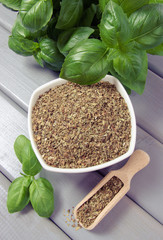 Fresh and dried basil on a wooden background.