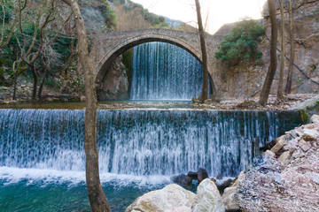 Stone arched bridge of Palaiokarya village with its artificial two waterfalls in Trikala, Greece