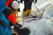 A group of climbers on a snow-covered mountain slope secured on a safety rope. Climbing station. Tilt-shift effect.