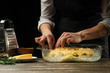 © Anton - The chef prepares focaccia bread or pizza with olives, butter, cheese and rosemary greens. Recipe for home cooking from the chef. Background for design or menu