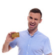 © Elena Kharichkina - Happy smiling young man showing credit card isolated on white background