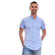 © Elena Kharichkina - Casually handsome. Confident young handsome man in jeans shirt keeping arms crossed and smiling while standing against white background