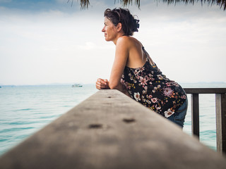 Relaxed caucasian woman is looking over the sea in Thailand