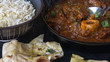 Goat Curry. Authentic Indian Cast Iron Curry Dish Served with Basmati Rice and Naan