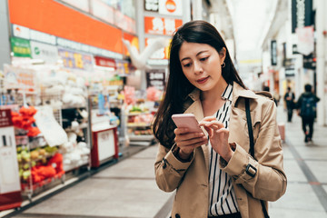 Wall Mural - Asian girl using phone checking shopping list