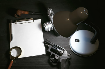 Wall Mural - blank page, pen, film photo camera, magnifying glass, handgun and smoking pipe on a black detective 