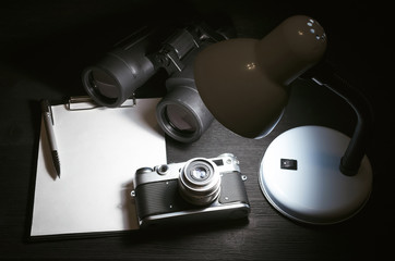 Wall Mural - blank page with copy space, pen, binoculars and photo camera on a black spy agent or paparazzi photo