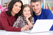 © aletia2011 - Close up portrait of parents and daughter using laptop in room