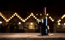 Red Wine Glass Near Bottle With Light Bokeh In Background