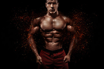 Wall Mural - Brutal strong muscular bodybuilder athlete man pumping up muscles on black background. Workout bodybuilding concept. Copy space for sport nutrition ads.