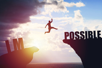 Silhouette of business man jump to success text over a beautiful view mountain background