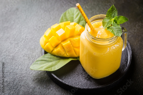 Fotomural Refreshing and healthy mango smoothie in a glass with fresh fruit over stone bac