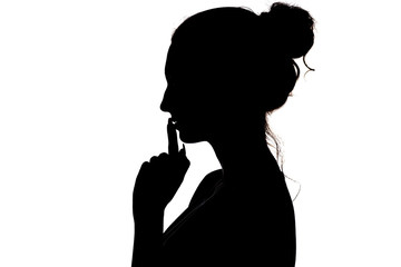 Wall Mural - young woman making a sign by finger near lips that means silence or secret, silhouette profile of unknown girl with a bun, privacy concept