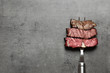 © New Africa - Fork with pieces of delicious barbecued meat on gray background, top view. Space for text