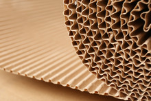 Closeup View Of Roll Of Brown Corrugated Cardboard, Space For Text. Recyclable Material